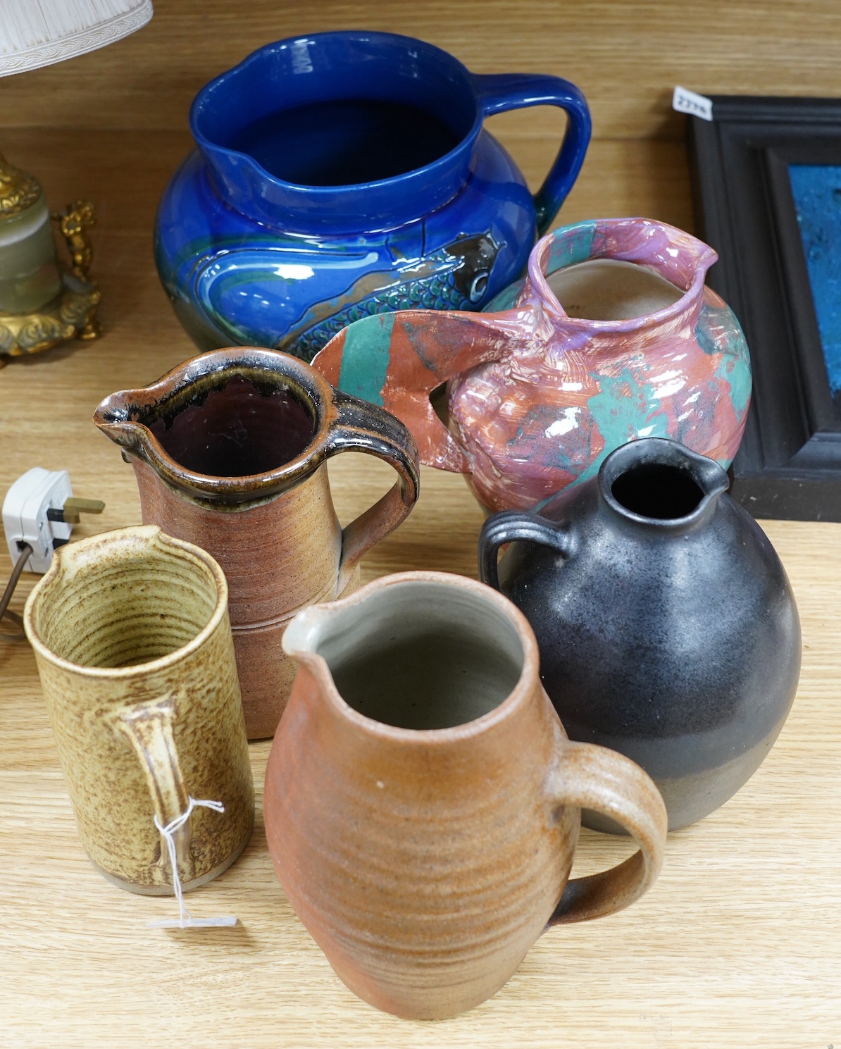 A group of six pottery jugs, to include GH Brannam, Muchelney and Bovey Tracey Art Pottery, largest 20cm high